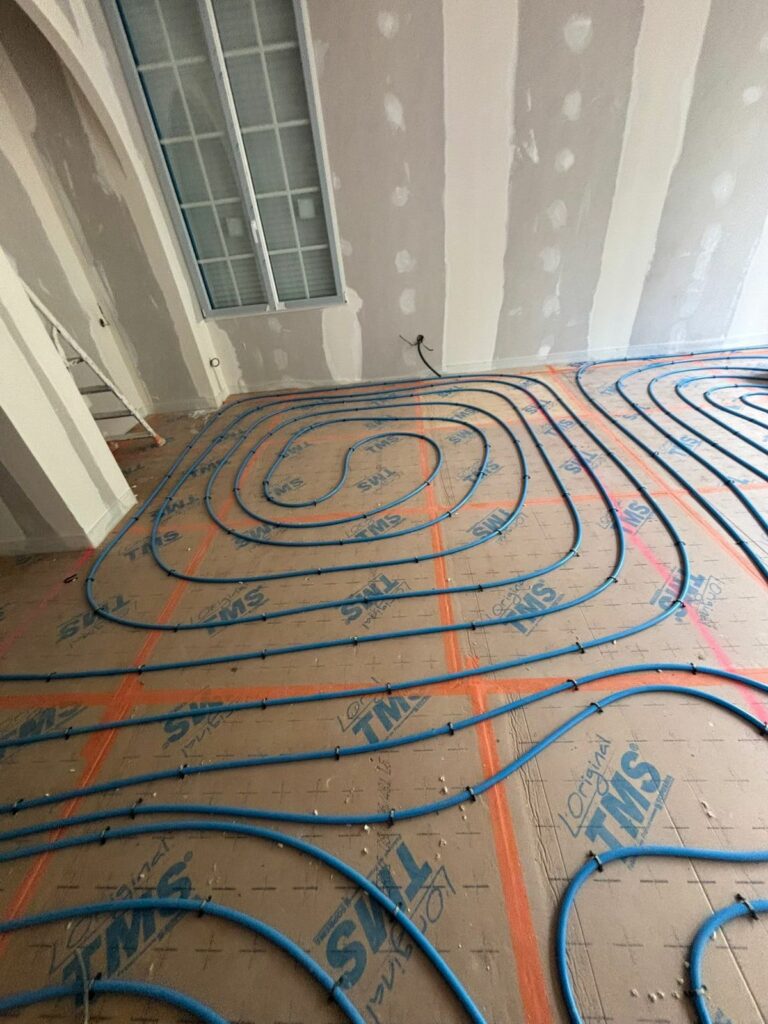 Plancher chauffant en cours de pose sur isolant, avant la chape et le revêtement de sol